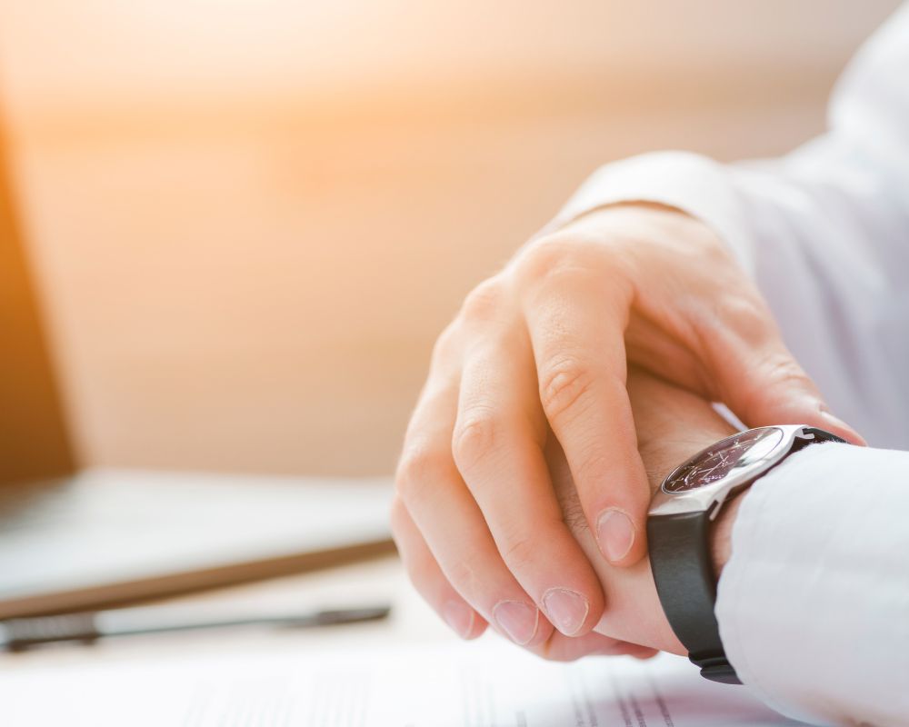 Persona mirando el reloj, representando la falta de tiempo para avanzar en la publicación de un libro.